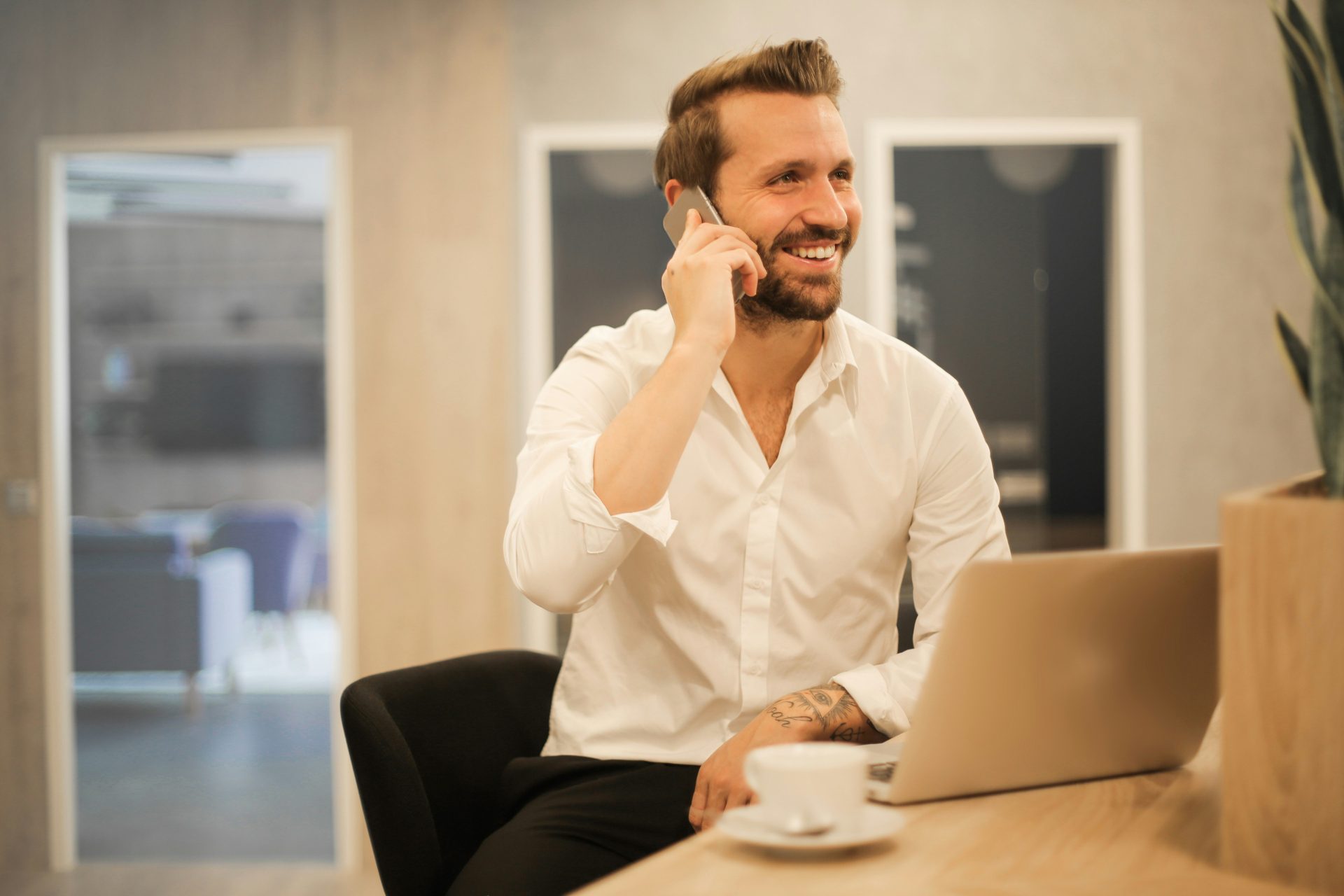 Man in white shirt talks on phone